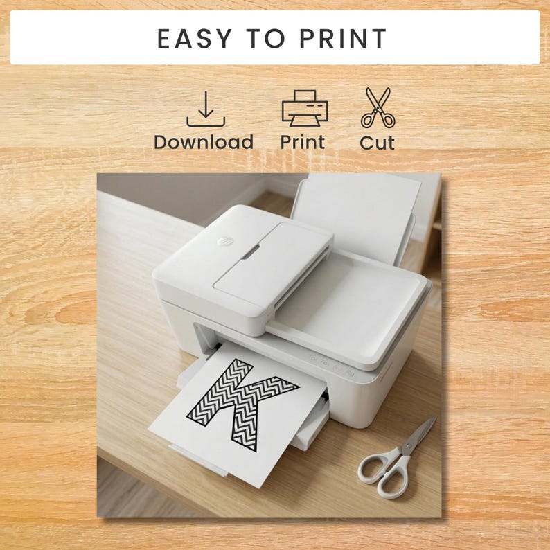 May include: A white inkjet printer with a sheet of paper featuring a black and white chevron patterned letter K. Above the printer, the text EASY TO PRINT is displayed with icons for Download, Print, and Cut. A pair of silver scissors sits nearby.