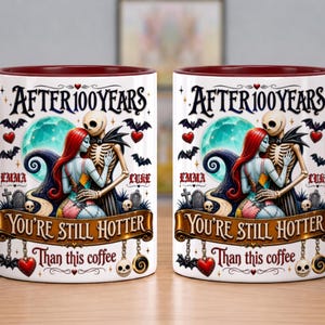 Puede incluir: Una taza de cer&aacute;mica blanca con asa y borde rojo oscuro, que presenta un gr&aacute;fico de dos figuras esquel&eacute;ticas abrazadas. El texto dice AFTER 100 YEARS YOU'RE STILL HOTTER THAN THIS COFFEE, con los nombres EMMA y LUKE impresos a los lados.