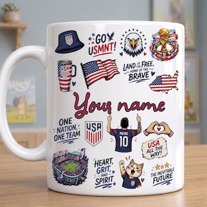 May include: A white ceramic mug featuring a collage of USA soccer-themed graphics, including a bucket hat, a tumbler, an American flag, a bald eagle, a map of the USA, a stadium, a cat, and a player in a jersey with the number 10 and text Your name.