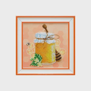 May include: Framed artwork featuring a detailed, beaded depiction of a honey jar with a wooden honey dipper. The jar is filled with golden honey, and a bee and honeycomb are also shown. The frame is orange and white.