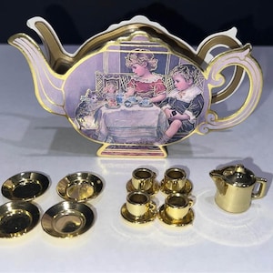 Juego de té vintage en miniatura: platos y tazas para casa de muñecas con tetera de cartón y estuche de transporte.