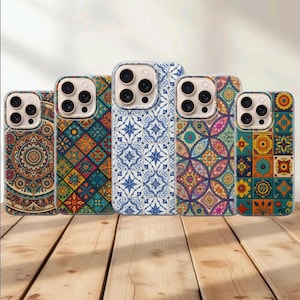 Può includere: Cinque cover per smartphone disposte in fila, ognuna caratterizzata da un distinto motivo ispirato alle piastrelle. I design includono mandala complessi, forme geometriche e motivi floreali nei toni del blu, arancione, giallo, verde e rosa.