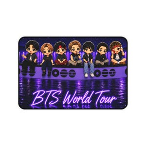 May include: A rectangular desk mat featuring seven chibi-style cartoon figures sitting on a purple curved structure above a dark purple water reflection. The text BTS World Tour is written in a glowing neon purple script at the bottom of the mat.