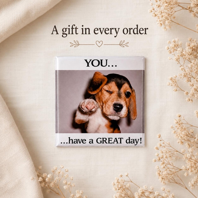 May include: A square magnet featuring a photograph of a brown, black, and white beagle puppy winking and extending a paw. The text above the puppy reads YOU... and the text below reads ...have a GREAT day! The magnet has a white border.