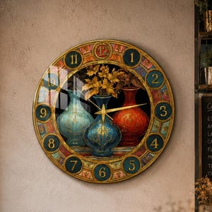 Pode incluir: Um relógio de parede redondo com uma borda decorativa com números dourados de um a doze. O centro exibe uma ilustração colorida de três vasos ornamentados em tons de azul, azul-petróleo e vermelho, com ponteiros dourados no centro.