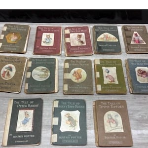 May include: A collection of fourteen small hardcover books by Beatrix Potter, featuring various titles such as The Tale of Peter Rabbit, The Tale of Benjamin Bunny, and The Tale of Squirrel Nutkin, each with a central illustration on the cover.