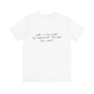 Könnte beinhalten: Weißes T-Shirt mit dem handgeschriebenen Text "LIFE IS TOO SHORT DO WHATEVER THE FUCK YOU WANT" in schwarzer Tinte. Das Shirt hat einen Rundhalsausschnitt und ist aus weichem Material.