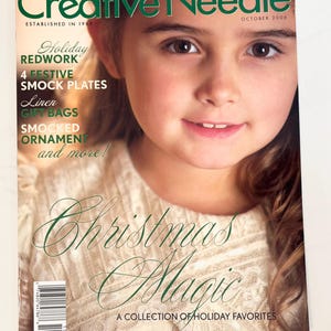 May include: The cover of "Creative Needle" magazine, October 2006, features a young girl smiling. The magazine's title is in green, with the words "Christmas Magic" in elegant script. The cover also mentions "Holiday Redwork" and "Smocked Ornament."