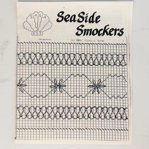 May include: A vintage pattern sheet titled "Sea Side Smockers" with a seashell logo. The sheet features a grid design with floral and wave-like patterns, and the text "(c) 1983 Sylvia S. Baird". The paper is off-white.