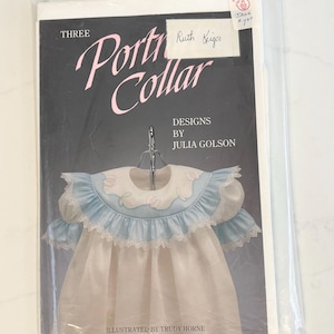 May include: A sewing pattern titled "Three Porti Collar Designs" by Julia Golson, illustrated by Trudy Horne. The cover features a light blue and white dress design with lace trim. The pattern is in a clear plastic sleeve.
