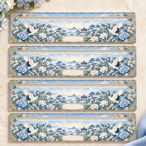 May include: Four rectangular metal license plate frames featuring a blue and white landscape illustration with cranes, lotus flowers, and a pagoda. Each frame has a horizontal slot and a central blank oval plaque for custom text.