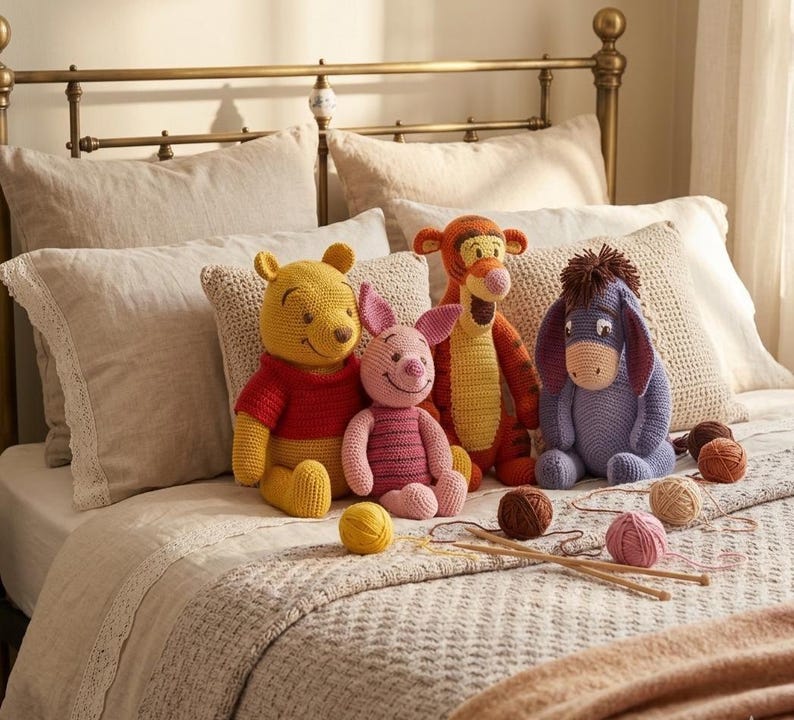 May include: A collection of handmade crochet Winnie the Pooh characters, including Winnie, Piglet, Tigger, and Eeyore, are arranged on a bed with yarn and knitting needles. The toys are in bright colors, with yarn balls and knitting needles.