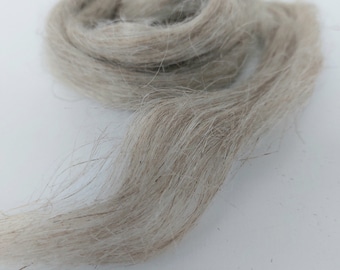 May include: A close-up of a bundle of natural, off-white flax fibers. The fibers are soft and fluffy, and they are perfect for spinning or weaving.