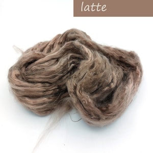 May include: A pile of light brown and beige wool fiber, labeled "latte".