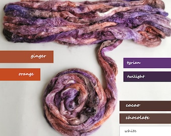 May include: A bundle of colorful silk fibers in shades of purple, pink, orange, brown, and white. The fibers are arranged in a loose, flowing pile. The colors are labeled with names like "ginger", "tyrian", "twilight", "cocoa", "chocolate", and "white".
