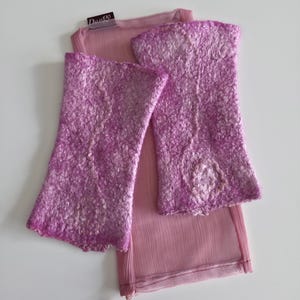 May include: Lavender fingerless gloves with a textured finish, alongside a sheer, light pink scarf. The gloves and scarf are displayed on a white surface. The gloves have a flared design. The label reads "Dante".