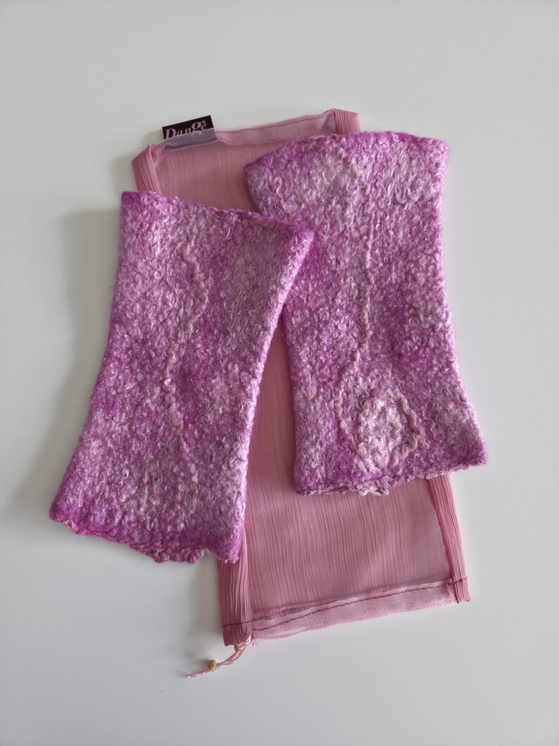May include: Lavender fingerless gloves with a textured finish, alongside a sheer, light pink scarf. The gloves and scarf are displayed on a white surface. The gloves have a flared design. The label reads "Dante".