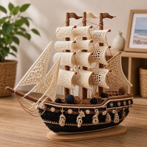 Peut inclure: Un modèle de navire en crochet fait main avec une coque bleu marine foncé et marron, doté de voiles et d'un gréement couleur crème. Le bateau comprend trois mâts, des boutons décoratifs sur le côté et des pelotes de laine sur le pont.
