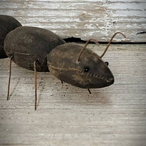 Pu&ograve; includere: Una formica di stoffa marrone con gambe e antenne di filo metallico. La formica &egrave; seduta su una superficie di legno chiaro.