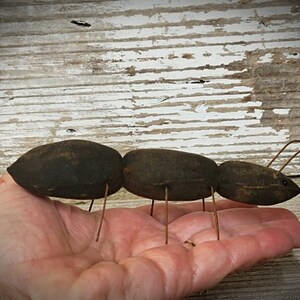 Pu&ograve; includere: Una formica di stoffa marrone fatta a mano con gambe di filo metallico. La formica &egrave; seduta sulla mano di una persona.