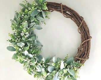 May include: A green and brown wreath with a vine base and eucalyptus leaves.