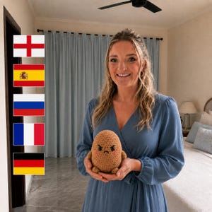 May include: A small, tan, crocheted plush toy shaped like a potato with a grumpy facial expression, featuring embroidered black eyes, a small frown, and two tiny arms and feet, held in two hands.