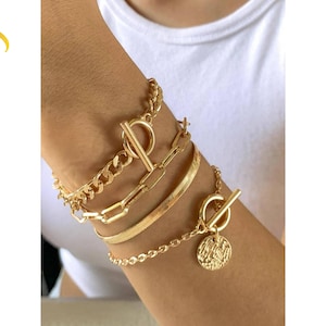 Armband med guldkedjor, minimalistisk skiva, lager och stapel