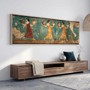 May include: A rectangular wall art print featuring a classical fresco style painting of three figures in draped robes carrying bowls against a teal background with a decorative Greek key border, framed in a light wood frame and mounted on a wall.