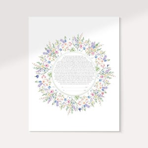 May include: A rectangular paper print featuring a circular wreath of watercolor wildflowers in shades of pink, blue, purple, and green. The center contains a block of Hebrew text with two blank lines at the bottom for signatures and dates.