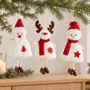 Può includere: Tre decorazioni natalizie sospese raffiguranti Babbo Natale, una renna e un pupazzo di neve. Ogni figura ha un corpo in pelliccia sintetica bianca, dettagli rossi e gambe penzolanti con stivali marroni, appese a fili bianchi.