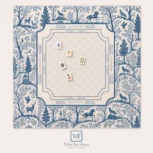 May include: A square Mahjong mat featuring a blue and cream toile de jouy pattern with forest animals and trees. The centre area includes game instructions and directional text, with five Mahjong tiles scattered across the surface.