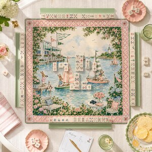 May include: A square mahjong mat featuring a nautical scene with rabbits sailing boats, a dock, and a clubhouse. The mat is bordered by a pink and white lattice pattern. Four green tile racks hold ivory mahjong tiles with various symbols.