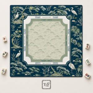 May include: A square mahjong mat with a dark blue border featuring white cranes, pine trees, and floral motifs. The center is light beige with a green frame containing text instructions like Charleston 1, 2, and 3, and play directions.