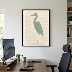 Puede incluir: Lámina artística enmarcada con una ilustración de una garza azul en el agua. La garza, con su largo cuello y patas, se representa en un estilo minimalista. La obra, enmarcada en negro, se presenta sobre un fondo claro, ideal para la decoración del hogar.