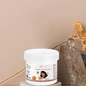 Peut inclure: Un pot en plastique blanc de crème Turmeric Knuckles avec un couvercle à vis. L'étiquette présente le nom du produit, une petite image d'une personne, un graphique de racines de curcuma et le texte 2 oz. Le pot est posé sur une base circulaire.