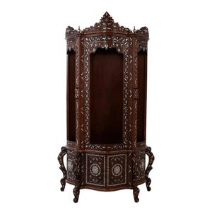 May include: A tall, dark brown wooden corner cabinet featuring intricate white floral and geometric mother-of-pearl inlay patterns. The piece has a curved front, open display sections, and ornate carved legs with matching decorative accents.