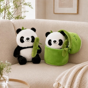 May include: Two plush panda toys. One panda sits upright holding a green bamboo stalk. The second panda is partially tucked inside a green, cylindrical, zippered plush container that resembles a bamboo shoot, with a small bamboo stalk attached.