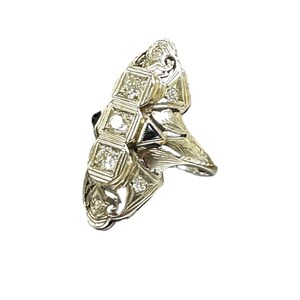 Pu&ograve; includere: Un anello d'oro con un design unico che presenta un gruppo di piccoli diamanti e una pietra nera pi&ugrave; grande al centro.