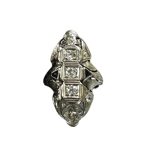 Pu&ograve; includere: Un anello d'argento con un design delicato che presenta una fila di cinque diamanti a taglio cuscino incastonati in un motivo geometrico.
