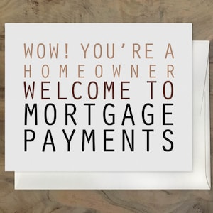 May include: A white card with the text "WOW! YOU'RE A HOMEOWNER WELCOME TO MORTGAGE PAYMENTS" in black and brown lettering.