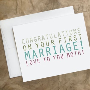 May include: A white card with the text "Congratulations on your first marriage! Love to you both!" in colorful lettering.