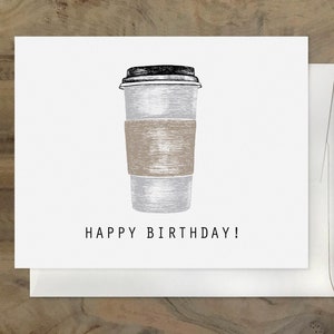 May include: A white and gray coffee cup with a brown paper sleeve and a black lid. The text "HAPPY BIRTHDAY!" is printed below the cup.