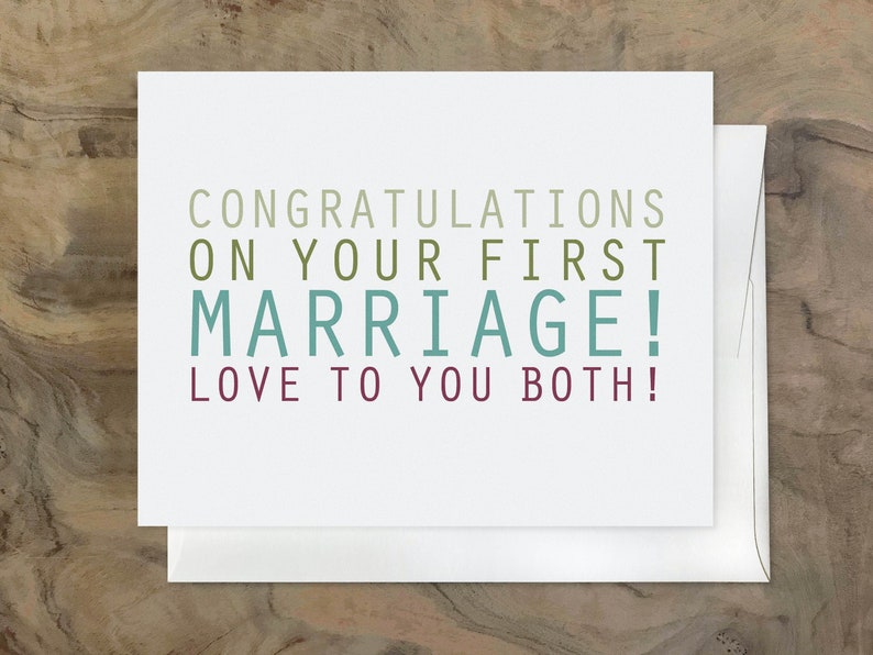 May include: A white card with the text "Congratulations on your first marriage! Love to you both!" in green, teal, and purple lettering.