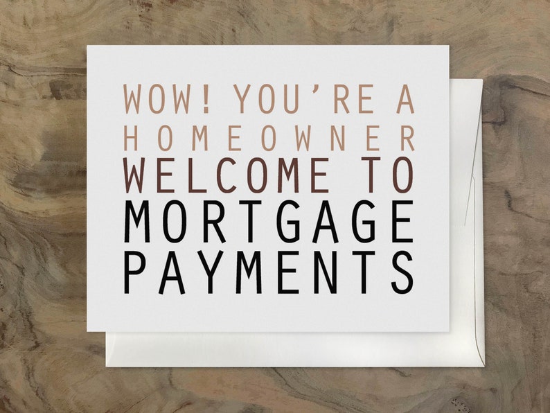 May include: A white card with the text "WOW! YOU'RE A HOMEOWNER WELCOME TO MORTGAGE PAYMENTS" in black and brown lettering.