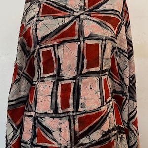 May include: A fabric featuring a geometric batik pattern in shades of deep red, off-white, and black. The design consists of repeating rectangular and triangular shapes separated by thick black lines, with a characteristic crackled texture.