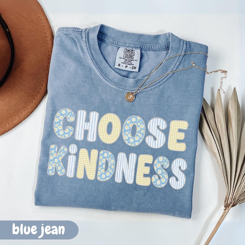 blue jean Comfort Colors Choose Kindness shirt featuring pastel daisy and gingham patterned lettering, inspirational teacher apparel, positive message graphic tee, kindness shirt for women, teacher appreciation gift, motivational comfort colors t-shirt.