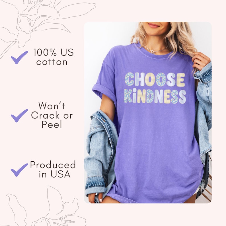 Puede incluir: Una camiseta morada de manga corta con el texto CHOOSE KINDNESS impreso en una fuente con patrones azul claro y amarillo. La imagen incluye texto que indica 100% US cotton, Won't Crack or Peel y Produced in USA con marcas de verificaci&oacute;n azules.