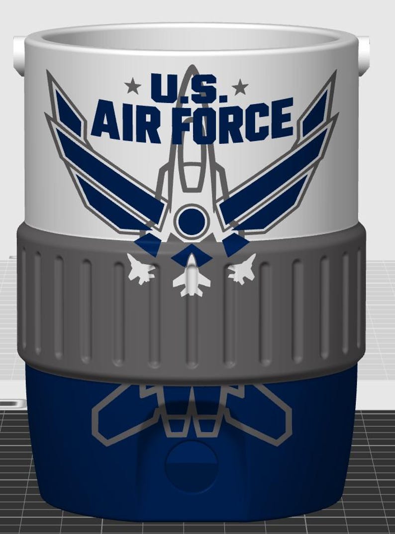 May include: A cylindrical white and blue cooler featuring the U.S. Air Force logo in dark blue text with a stylized aircraft graphic. The middle section has a textured gray band, and the lower blue portion displays a faint gray aircraft outline.