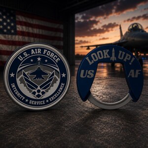 May include: A circular U.S. Air Force challenge coin featuring the official emblem and the text Integrity, Service, Excellence, alongside a blue U-shaped bottle opener with the text Look Up! and US AF, both displayed against a hangar background.