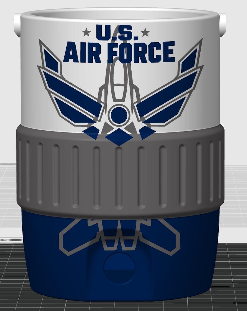 May include: A white and blue cylindrical cooler featuring the text U.S. AIR FORCE in dark blue letters above a stylized graphic of a fighter jet. The cooler has a wide, textured grey band around the middle and a solid dark blue base section.